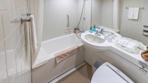 a bathroom with a sink and a tub and a toilet at Premier Hotel Nakajima Park Sapporo in Sapporo