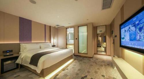 a bedroom with a large bed and a flat screen tv at Lavande Hotel Wuhan Jianghan Road Dunli Gate Metro Station in Wuhan
