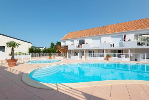 une grande piscine devant un immeuble dans l'établissement Resid Azur, à Saint-Jean-de-Monts