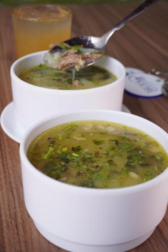 two bowls of soup on a table with a spoon at Hotel Bello Caribe Rodadero in Santa Marta