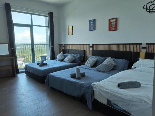 two beds in a room with a large window at Baysuites Likas 9pax City Views L 21 near kk town in Likas