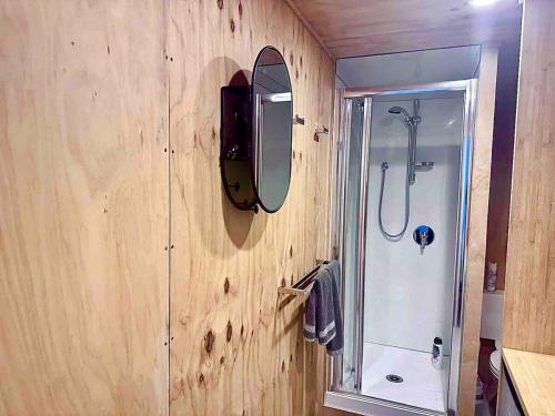 a bathroom with a shower and a mirror on the wall at Self-contained Tiny Sleepout in Hamner in Hanmer Springs