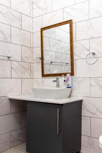 a bathroom with a sink and a mirror at The Space Guesthouse Mondlo in Mondlo