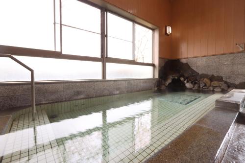 a swimming pool with a window and water in it at 森のやかた湯ったり館 