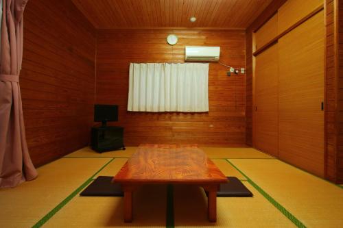 a room with a table in the middle of a room at 森のやかた湯ったり館 