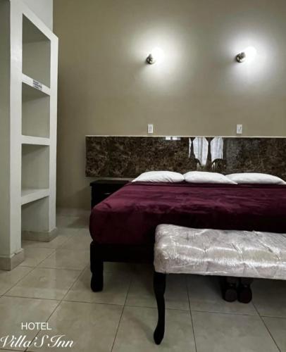 a bedroom with a bed and a bench in it at Hotel Villas Inn in Sofía