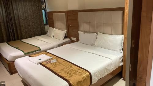 Dos camas en una habitación de hotel con toallas encima. en Hotel RR inn-International Airport, en Bombay