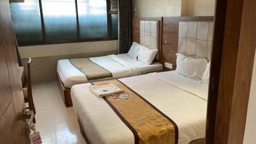 Una habitación de hotel con dos camas y una ventana. en Hotel RR inn-International Airport, en Bombay