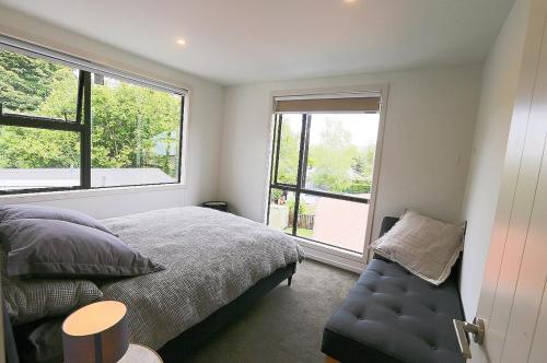 a bedroom with a bed and a large window at Stunning Mountain Views in Renovated Hamner Home in Hanmer Springs
