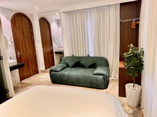a living room with a green couch and a bed at ChiPa Homestay in Da Nang