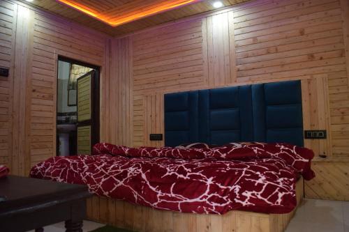 a bedroom with a bed in a wooden wall at Green valley homestay in Khajjiar 