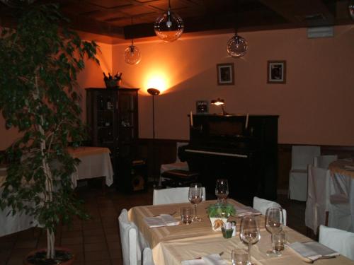 a dining room with a table and a piano at Albergo Michieletto in Valmorea