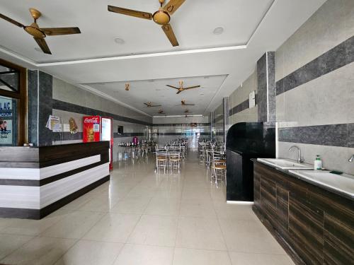 a room with a restaurant with tables and chairs at SR Hotel in Renigunta