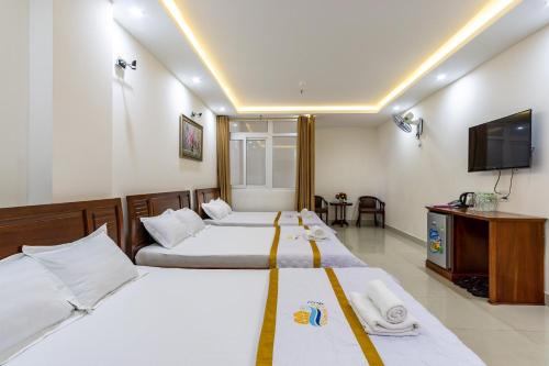 a hotel room with two beds and a flat screen tv at Diamond Sea Hotel in Vung Tau