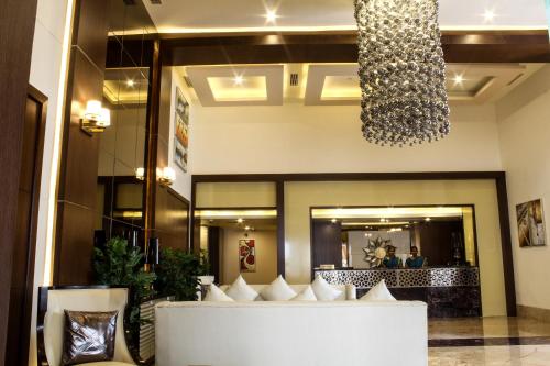 a lobby with a white couch and a chandelier at Hotel Southern Comfort in Chennai