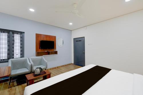 a bedroom with a bed and a table and chairs at Super Townhouse Vanasthalipuram Near Deer National Park in Hyderabad