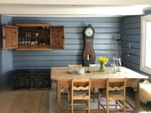 a dining room with a table and a clock on the wall at Farm In The Heart Of Gudbrandsdalen in Moss