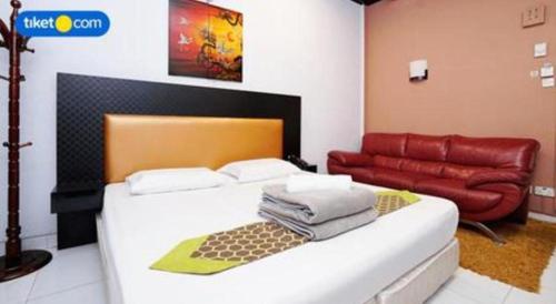 a bedroom with a bed and a red couch at Lai Ming Hotel Cosmoland in Singapore