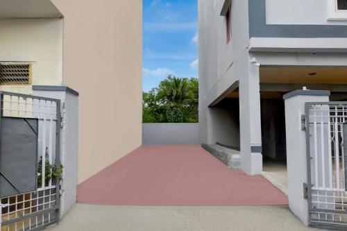 a corridor of a white building with a gate at Super Townhouse Vanasthalipuram Near Deer National Park in Hyderabad