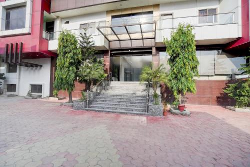a building with stairs and trees in front of it at Super Townhouse Lalghati Near Airport in Bhopal