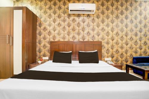 a bedroom with a white bed and a blue chair at Super Townhouse Lalghati Near Airport in Bhopal