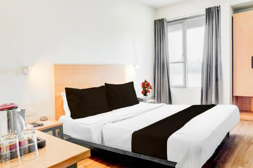 a bedroom with a large white bed and a window at Super Townhouse MG Road Pune in Pune