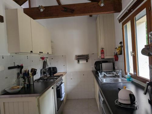 a kitchen with a sink and a stove top oven at Gîte Belle, Piscine privée, vue sur la campagne in Nonac