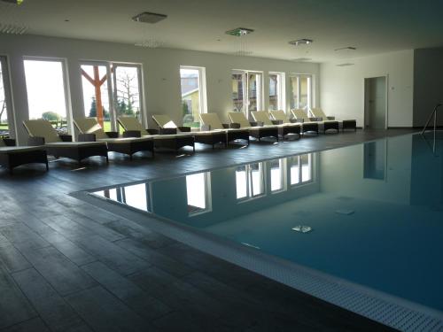 a swimming pool with chairs and tables in a building at Spreewaldhof Romantik - Hotel Garni in Neu Zauche