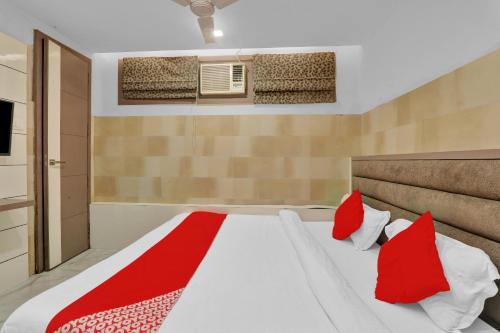 a bedroom with a large bed with red pillows at Super Hotel O Sada Shiv Guest House in Gorakhpur