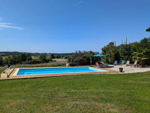 a swimming pool in a yard with a grass field at Gîte Belle, Piscine privée, vue sur la campagne in Nonac