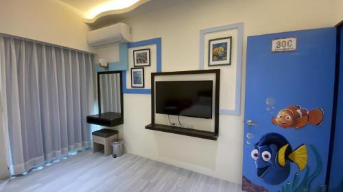 a living room with a flat screen tv on a wall at 台東漫活電梯民宿-可包棟 in Taitung City