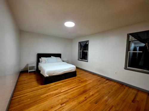 a bedroom with a bed and a wooden floor at Cozy City Nest in Jersey City