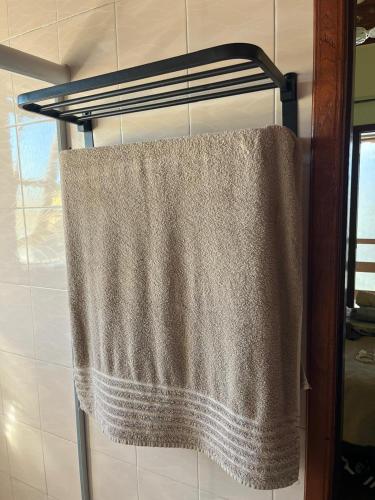 a towel hanging on a towel rack in a bathroom at Duplex 450m da Praia do Peró, Roupa Cama e Banho, Wi-Fi, TV a Cabo, Estacionamento in Cabo Frio
