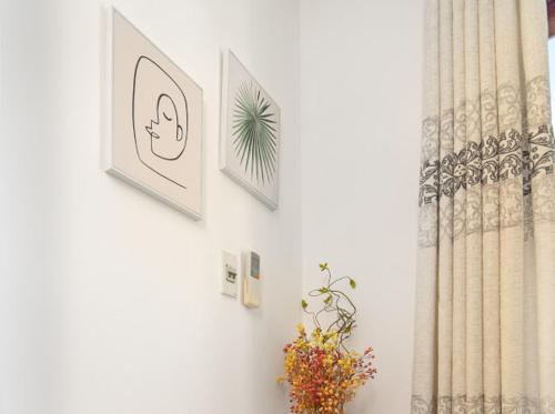 a room with two pictures on the wall and a window at ChiPa Homestay in Da Nang