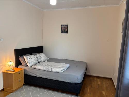una piccola camera da letto con un letto e un comodino di Malmi Home a Vaasa