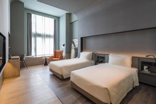 a hotel room with two beds and a television at Atour S Hotel Shanghai Hongqiao Center Aegean-Late night Congee in Shanghai