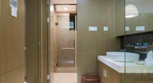 a bathroom with a sink and a shower in it at Da Peng Zhongzhou Hotel in Haikou