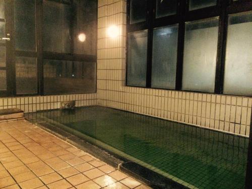 an empty swimming pool in a building with windows at Kashiwaya in Chikuma