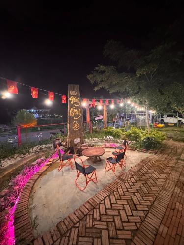 two chairs and a table in a park at night at Đông Giang Sky Villa in A Sơ Ră Amo