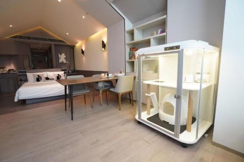 a room with a table and a bedroom with a bed at Atour S Hotel Shanghai Hongqiao Center Aegean-Late night Congee in Shanghai