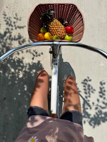 a person riding a bike with a basket of fruit at Grande Maldives Inn in Himmafushi