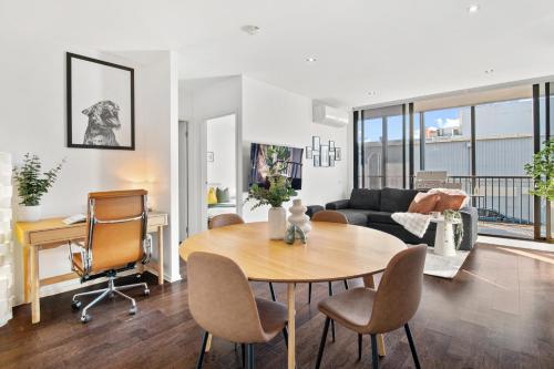 a living room with a table and chairs at Sunny Richmond Escape 2BR and Large Balcony in Melbourne