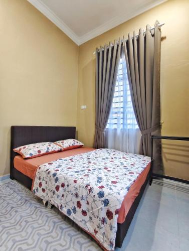 a bedroom with a bed and a window with curtains at Narasya Homestay Wakaf Tengah Batu Rakit in Kuala Terengganu