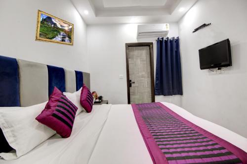 a bedroom with a bed with purple and white pillows at Hotel S B Inn Near New Delhi railway Station Paharganj in New Delhi