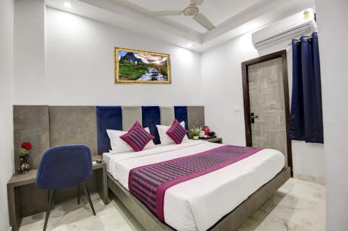 a bedroom with a large bed and a blue chair at Hotel S B Inn Near New Delhi railway Station Paharganj in New Delhi