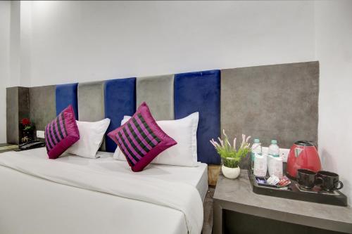two beds in a room with pink and purple pillows at Hotel S B Inn Near New Delhi railway Station Paharganj in New Delhi