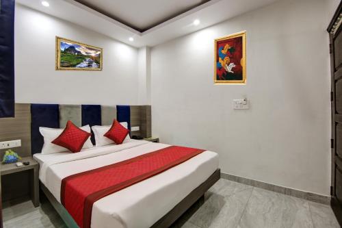 a bedroom with a large bed with red pillows at Hotel S B Inn Near New Delhi railway Station Paharganj in New Delhi