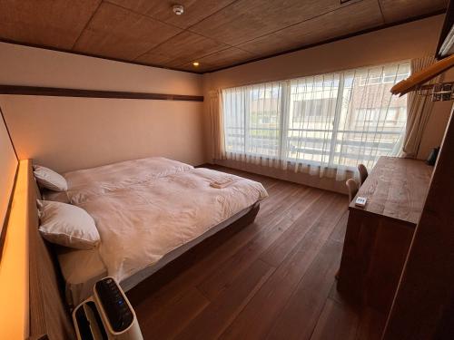 a small bedroom with a bed and a window at nirasakiyaSTAY in Nirasaki