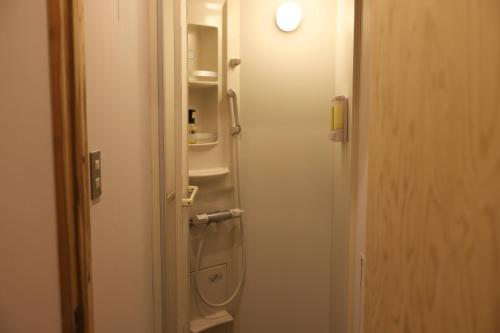 a door to a bathroom with a sink and shelves at nirasakiyaSTAY in Nirasaki
