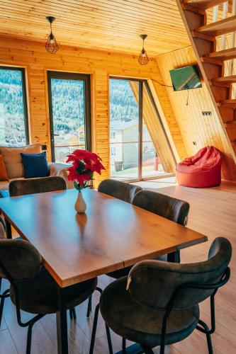 a dining room with a wooden table and chairs at A-frame Wonder Mountain Chalet in Mestia